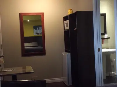 a room with a mirror and a cabinet and a sink at Miami Motel inc in Trois-Rivières