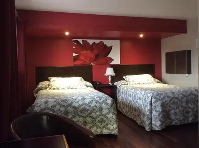 a bedroom with two beds and a red wall at Miami Motel inc in Trois-Rivières