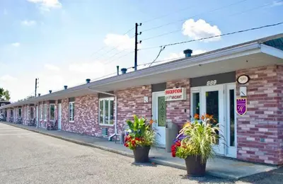 a brick building with potted plants in front of it at Motel Invitation in Sainte-Marie