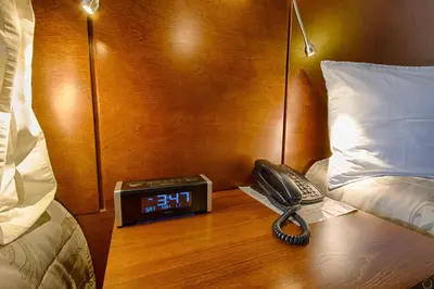 a phone and a alarm clock on a table in a hotel room at Motel Invitation in Sainte-Marie