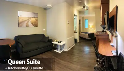 a living room with a couch and a table at Motel Invitation in Sainte-Marie