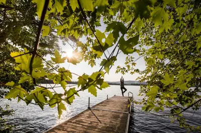 a woman standing on a dock on a lake at Domaine Jolivent in Lac-Brome