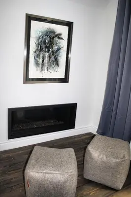 a living room with a chair and a fireplace at Domaine Jolivent in Lac-Brome