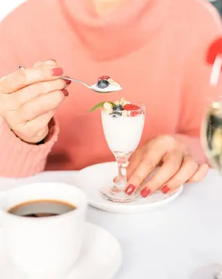 a woman is eating a dessert with a spoon at Domaine Jolivent in Lac-Brome
