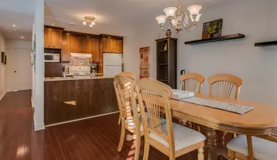 a kitchen and dining room with a wooden table and chairs at Condo Entre Ville/Nature in Magog-Orford