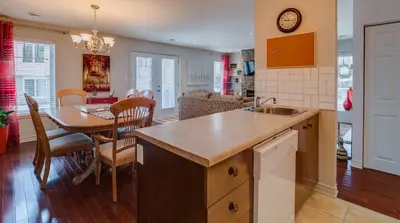 a kitchen and dining room with a table and a dining room at Condo Entre Ville/Nature in Magog-Orford