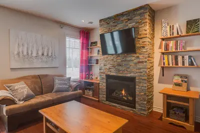 a living room with a couch and a fireplace at Condo Entre Ville/Nature in Magog-Orford