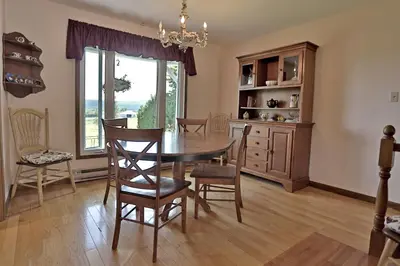 a dining room with a table and chairs and a window at Ranch St-Hubert in Saint-Herménégilde