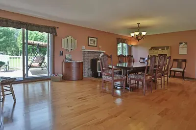 a dining room and living room with a table and chairs at Ranch St-Hubert in Saint-Herménégilde