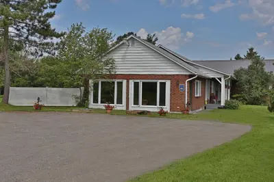 a house with a driveway in front of it at Ranch St-Hubert in Saint-Herménégilde
