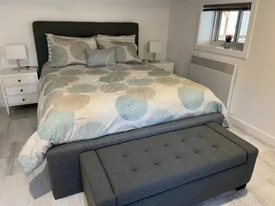 a bedroom with a large bed with a bench in it at Domaine Gagnon in Saint Sebastien