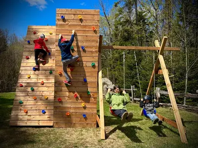 a group of people playing on a wooden climbing wall at Domaine Gagnon in Saint Sebastien