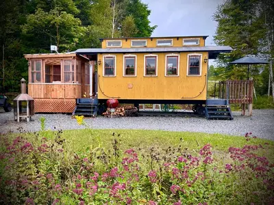 a yellow tiny house sitting in a yard at Domaine Gagnon in Saint Sebastien