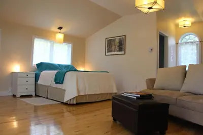 a bedroom with a bed and a couch at La Maison Jaune D'Eastman in Eastman