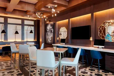 a restaurant with a bar with chairs and a tv at Sheraton Saint-Hyacinthe Hotel in Saint-Hyacinthe