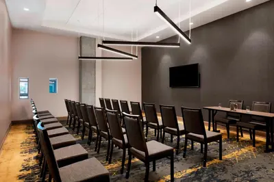 a conference room with chairs and a table and a tv at Sheraton Saint-Hyacinthe Hotel in Saint-Hyacinthe