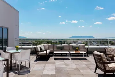a patio with a couch and tables and chairs at Sheraton Saint-Hyacinthe Hotel in Saint-Hyacinthe