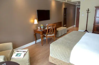 a hotel room with a bed and a desk with a chair at Hotel Brossard in Brossard