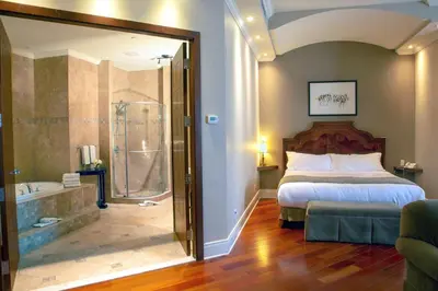 a bedroom with a bed and a shower and a tub at Hotel Brossard in Brossard