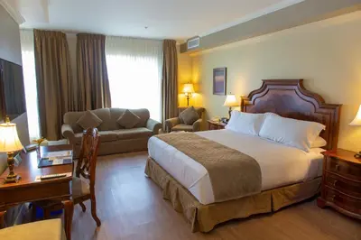 a hotel room with a bed and a couch at Hotel Brossard in Brossard