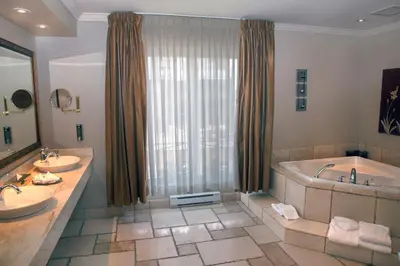 a bathroom with two sinks and a bath tub at Hotel Brossard in Brossard