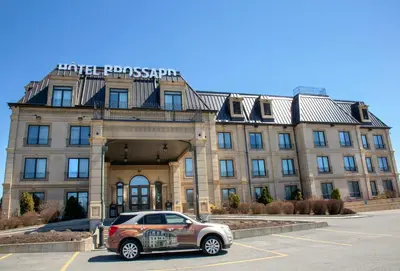 a car parked in a parking lot in front of a building at Hotel Brossard in Brossard