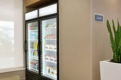 a refrigerator with its door open with food inside at Embassy Suites By Hilton Montreal Airport in Pointe-Claire
