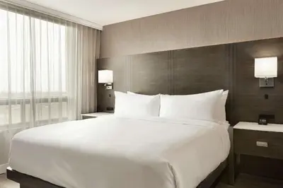 a large white bed in a hotel room at Embassy Suites By Hilton Montreal Airport in Pointe-Claire