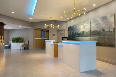 a lobby with a reception desk in a building at Embassy Suites By Hilton Montreal Airport in Pointe-Claire