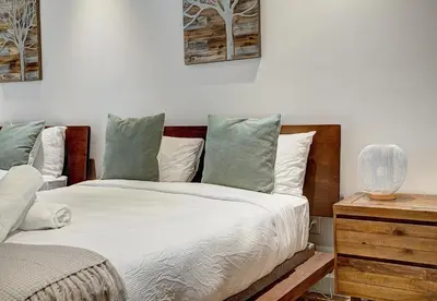 a bedroom with a bed with white sheets and a nightstand at Saint Sulpice Lofts by Bakan - Old Montreal in Montréal