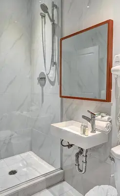 a bathroom with a shower and a sink and a mirror at Saint Sulpice Lofts by Bakan - Old Montreal in Montréal