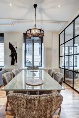 a dining room with a glass table and chairs at Saint Sulpice Lofts by Bakan - Old Montreal in Montréal