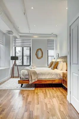 a bedroom with a large bed and wooden floors at Saint Sulpice Lofts by Bakan - Old Montreal in Montréal
