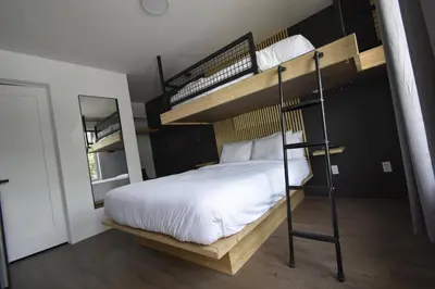 a bedroom with two bunk beds and a mirror at Motel ANF in Drummondville