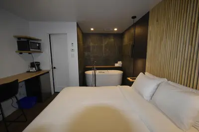 a hotel room with a bed and a bath tub at Motel ANF in Drummondville