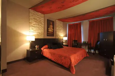 a hotel room with a bed and a flat screen tv at Motel Capri & Suites in Repentigny
