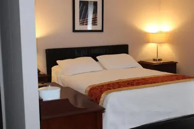a hotel room with a bed and two night stands at Motel Capri & Suites in Repentigny
