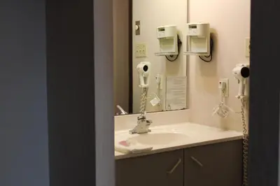 a bathroom with a sink and a mirror at Motel Capri & Suites in Repentigny