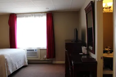 a hotel room with a bed and a window at Motel Capri & Suites in Repentigny