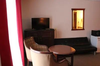 a living room with a couch a table and a television at Motel Capri & Suites in Repentigny