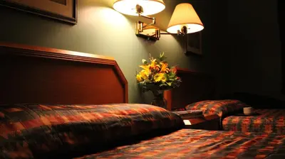 a hotel room with two beds and a vase of flowers at Hôtel Val-des-Sources in Asbestos