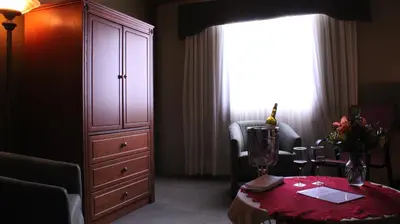 a room with a large dresser and a table with flowers on it at Hôtel Val-des-Sources in Asbestos