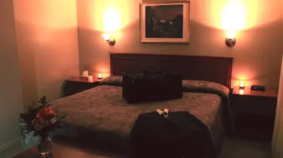 a hotel room with a bed with two bags on it at Hôtel Val-des-Sources in Asbestos