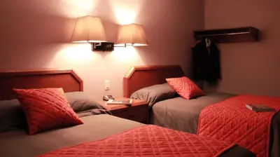 a hotel room with two beds with red sheets at Hôtel Val-des-Sources in Asbestos