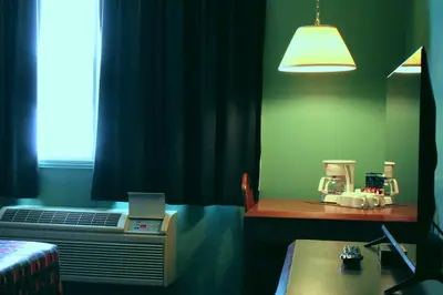 a room with a bed and a desk and a window at Hôtel Val-des-Sources in Asbestos