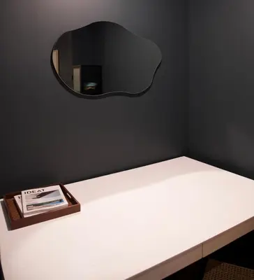 a mirror on a wall above a white table at Maison Saint-Vincent By Maisons & co in Montréal