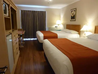 a hotel room with two beds and a television at Motel Becancour in Bécancour
