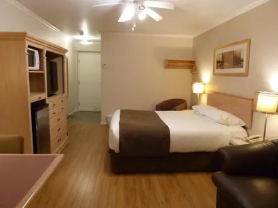 a hotel room with a bed and a living room at Motel Becancour in Bécancour