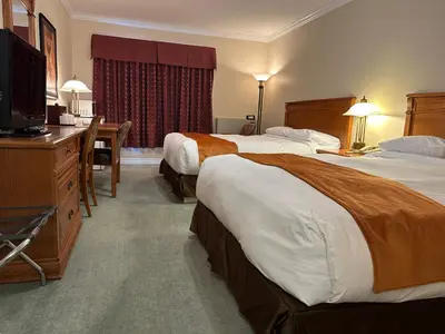 a hotel room with two beds and a television at Motel Becancour in Bécancour