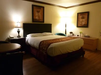 a hotel room with a large bed and two lamps at Motel Becancour in Bécancour